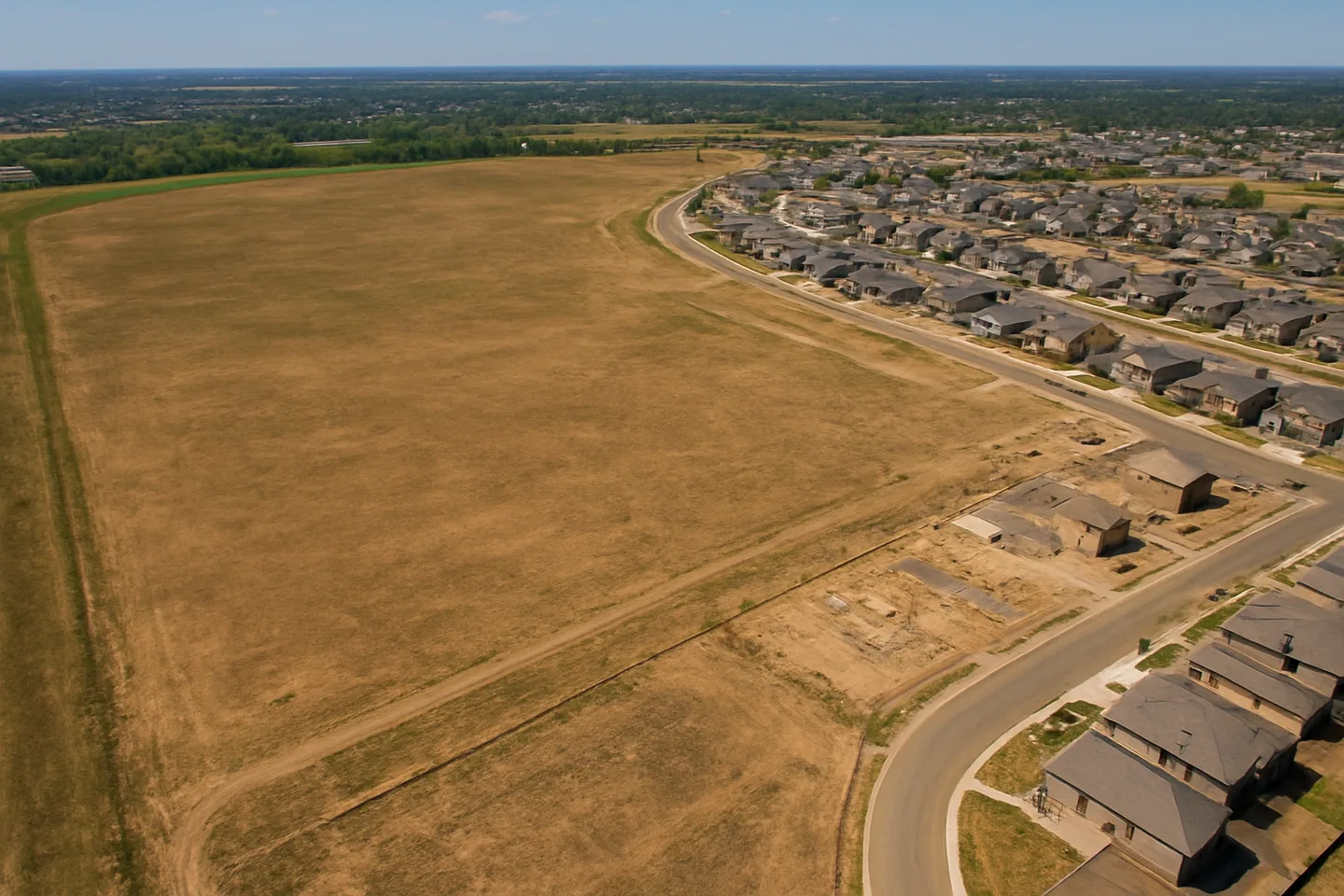 Aerial view of undeveloped land next to new construction